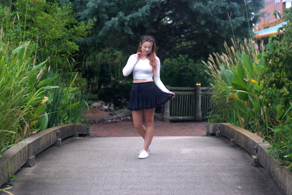 a girl who walks besides at the green leaves